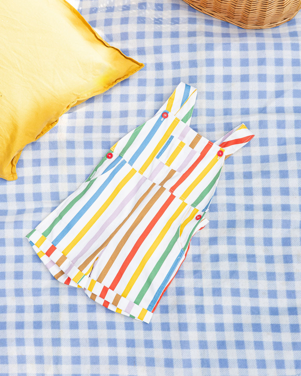 Rainbow stripe overall flatlay op picknickkleed