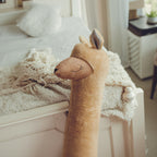 Plush deer toy on a soft surface with a blurred background