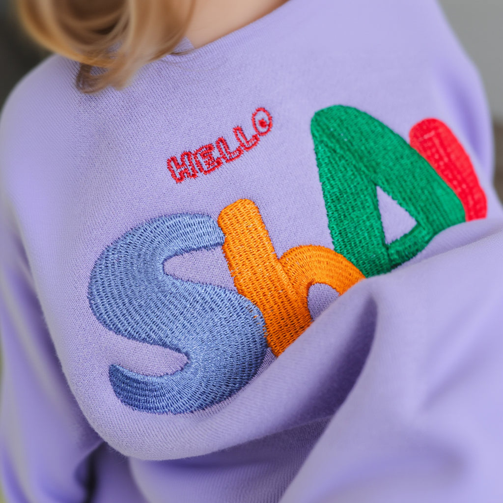 Hello Shams Original Set Soft Lilac — close-up of colorful HelloShams embroidery on lavender kids sweatshirt