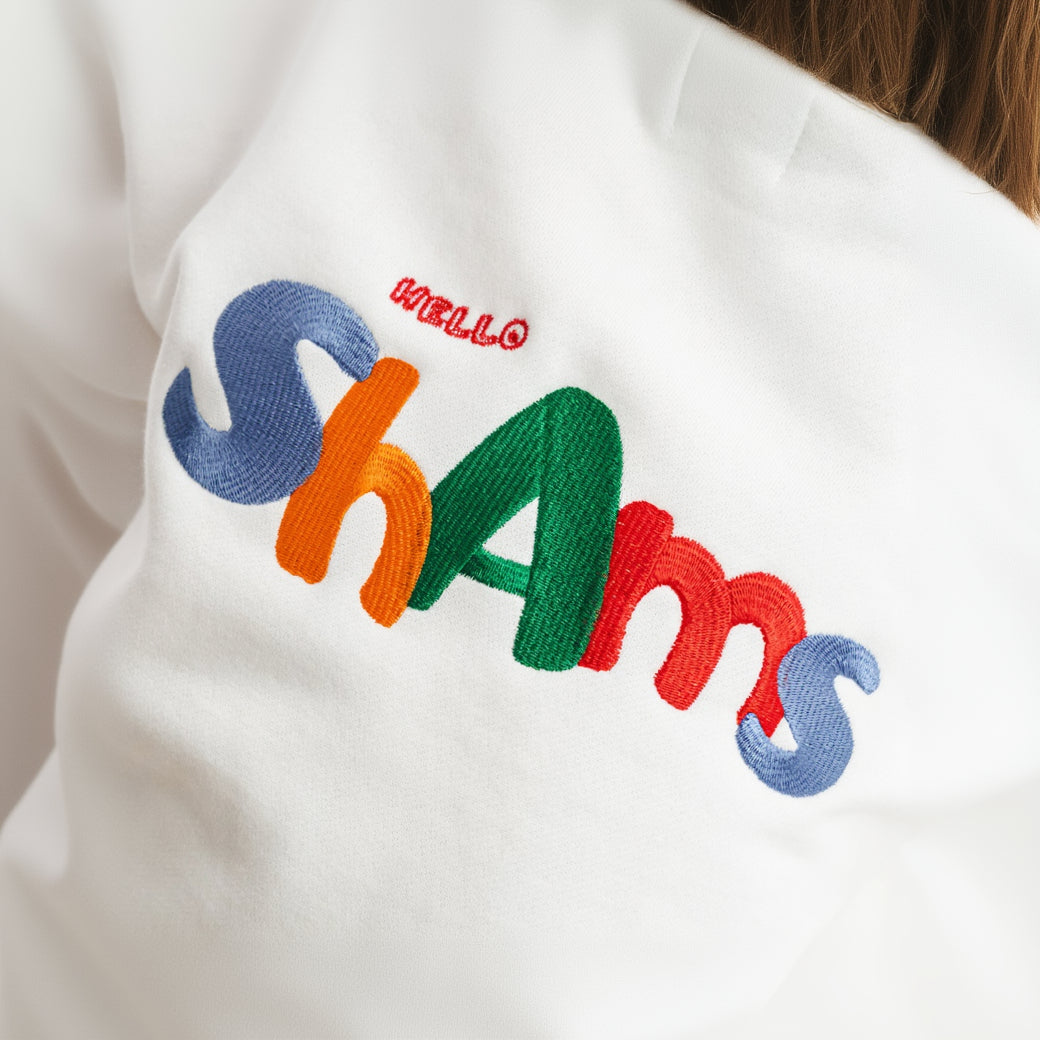 Embroidered text 'HELLO SHAMS' on a white background